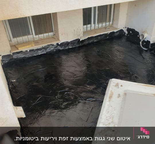 איטום גג עם חומר שחור ליד חלונות
